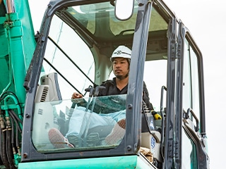ショベルカーを操作する重機オペレーター。建設現場での作業風景